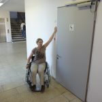 Picture of a person in a wheelchair beside the entrance to the accessible toilet.