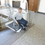 Picture of a wheelchair user exiting the stair lift at the top of the stairs.