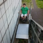 Photo showing a wheelchair user accessing the stair lift